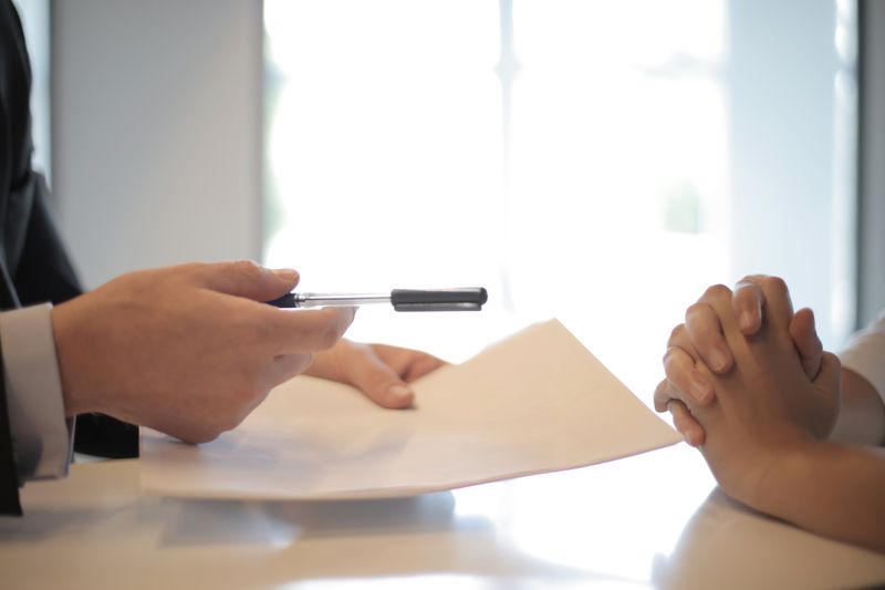 A woman reviewing a document with a colleague at a meeting table