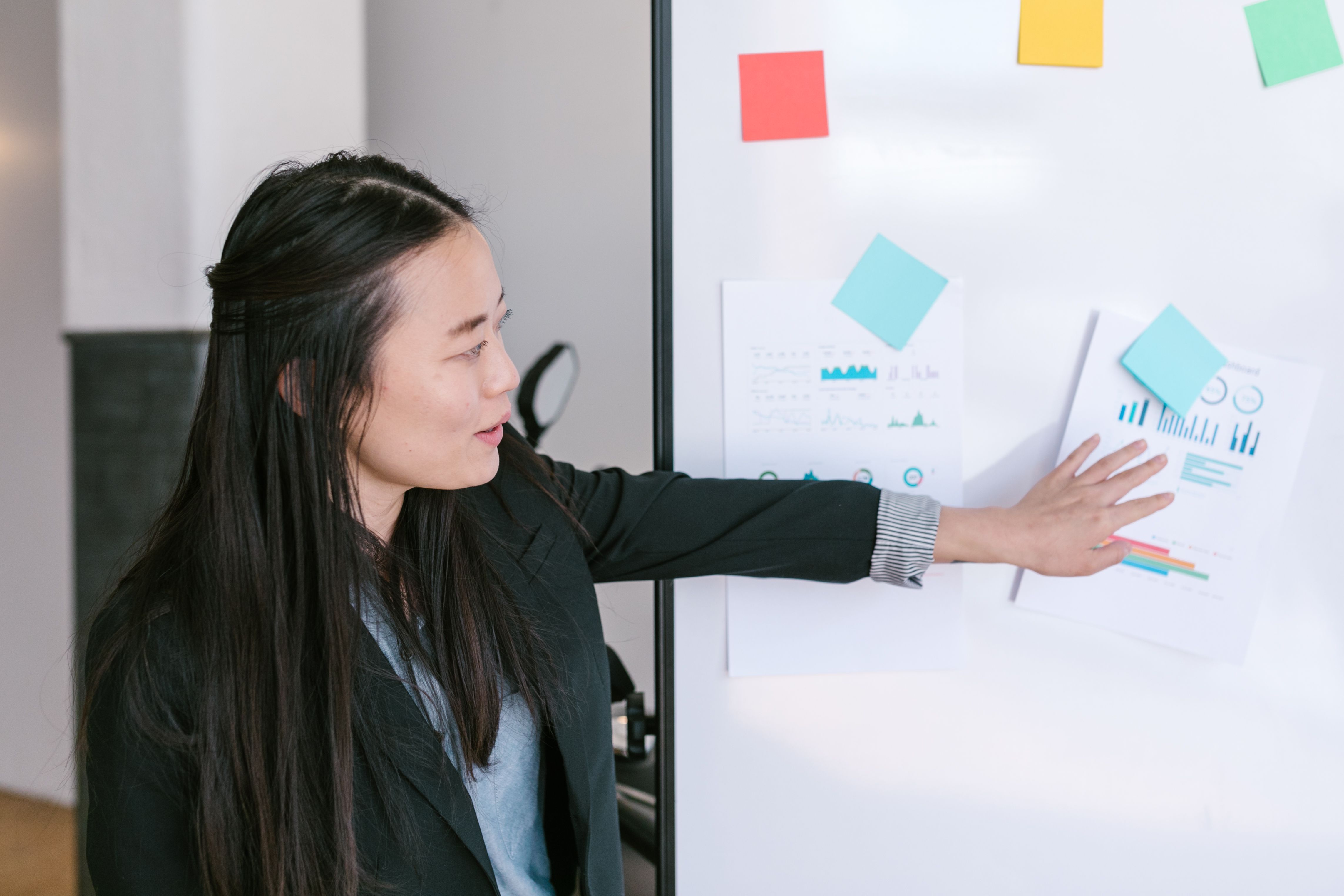 Asian businesswoman presenting business ideas at a whiteboard